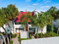 Condo building with red tile roof and lush landscaping at 760 Village Cir # 212, Venice, FL 34292