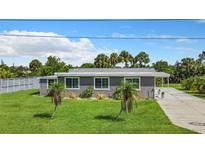 Ranch style home with gray siding and palm trees at 8430 Truman St, Englewood, FL 34224