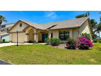 Charming single-story home featuring a tile roof, arched entryway, and a well-manicured lawn at 217 Carriage House Ln # 217, Nokomis, FL 34275