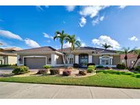 Charming single-story home with a well-manicured lawn, mature landscaping, and a tile roof at 594 Sawgrass Bridge Rd, Venice, FL 34292