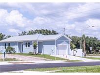 Newly constructed light blue single-Gathering home with a white garage door and landscaped yard at 17501 Belle Eden Way, Nokomis, FL 34275