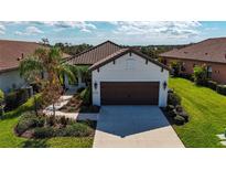 Single-story home with brown garage door and landscaped yard at 232 Carlino Dr, Nokomis, FL 34275