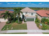 Two-story house with tile roof, green garage door, and well-manicured lawn at 23787 Waverly Cir, Venice, FL 34293
