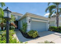 Light blue house with a two-car garage and nicely landscaped front yard at 12273 Stuart Dr, Venice, FL 34293