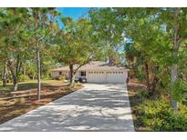 Single-story home with three-car garage and landscaped yard at 1817 Bridge St, Englewood, FL 34223