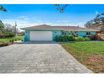 Teal home exterior with a paved driveway and landscaping at 2480 Alamander Ave, Englewood, FL 34223