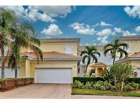 Front view of a charming two-story home with a white garage door at 1704 Triano Cir # 1704, Venice, FL 34292