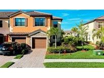 Two-story townhome with a two-car garage and well-manicured landscaping at 20391 Lagente Cir, Venice, FL 34293