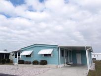 Charming single-story home with a covered carport and well-maintained landscaping under a cloudy sky at 359 Longwood Dr, Venice, FL 34285