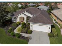 Single-story home with a two car garage and manicured landscaping at 648 Lakescene Dr, Venice, FL 34293