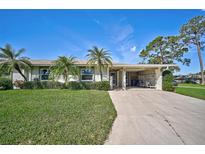 Condo building exterior with lush landscaping at 1402 Grand Blvd # 240, Sarasota, FL 34232