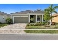 One-story house with green exterior and landscaped yard at 11925 Bohemian Pl, Venice, FL 34293