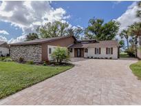 Charming two-story home with a stone facade, updated landscaping, and paved driveway at 1141 Sleepy Hollow Ct, Venice, FL 34285