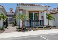 Cottage-style home with a gated walkway and landscaping at 132 Clifton Way, Venice, FL 34292