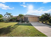 Charming single-Gathering home with an attached garage, well-manicured lawn and tropical landscaping at 1701 Boca Raton Ct, Punta Gorda, FL 33950