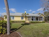 Charming yellow house with a large backyard and screened porch at 104 Sunrise Dr, Nokomis, FL 34275