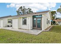Light-colored house with a brown door and a small patio at 6796 Gasparilla Pines Blvd # 62, Englewood, FL 34224