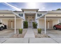 Inviting condo complex featuring covered parking, lush landscaping, and a welcoming entrance at 815 Montrose Dr # 103, Venice, FL 34293