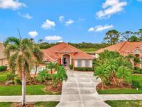 Single-story home with tile roof, landscaping, and large driveway at 1151 Creek Nine Dr, North Port, FL 34291