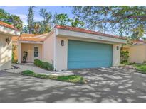 Charming villa featuring a tile roof and a two-car garage door painted light blue at 606 Marcus St # 26, Venice, FL 34285