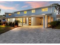 Stunning light blue home with a covered entryway and paved driveway at 842 Nokomis S Ave, Venice, FL 34285