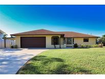 Single-story home with a large yard, attached garage, and carport at 3534 Tundra Rd, Venice, FL 34293