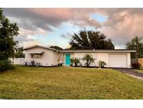 Cute mid-century home with turquoise door and well-manicured lawn at 4137 Maceachen Blvd, Sarasota, FL 34233