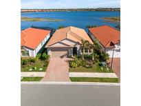 Waterfront home with lush landscaping, brick driveway, and proximity to the lake at 660 Ravello Blvd, Nokomis, FL 34275
