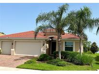 Single-story home with tile roof, two-car garage, and palm trees in the front yard at 11722 Goombay Ct, Venice, FL 34292