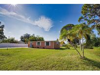 Cute Florida home with a spacious lawn, palm trees, and a fenced yard at 1605 Phillip Pl, Englewood, FL 34223