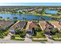 Aerial view of a luxury home community with lakefront properties at 19357 Jacinda St, Venice, FL 34293