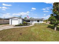 Ranch-style home with gray exterior, solar panels, and landscaped yard at 3304 Oxford W Dr, Bradenton, FL 34205