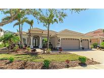 Charming single-story home with a tile roof, lush landscaping, and a three-car garage at 608 Crane Prairie Way, Osprey, FL 34229