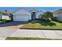 Single-story home with a white exterior, a large garage, and a well-manicured lawn at 816 Derbyshire Dr, Venice, FL 34285