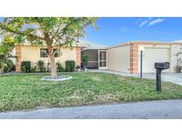 Charming single-story home with a well-manicured lawn, mature landscaping, and an inviting entrance at 124 Villa Dr # 124, Osprey, FL 34229