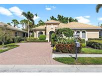 Attractive single-story home with a brick driveway and lush landscaping at 134 Savona Way, North Venice, FL 34275