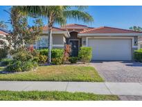 Attractive one-story home with a tile roof, landscaping, and a two-car garage at 19348 Yellowtail Ct, Venice, FL 34292