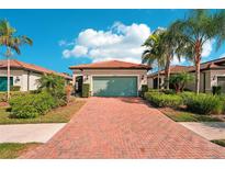 Single-story home with a light green garage door and brick driveway at 2572 Daisy Dr, North Port, FL 34289