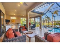 Beautiful screened-in patio with a swimming pool, dining area, kitchen and comfortable seating area at 5584 Cantucci St, Nokomis, FL 34275