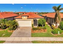 Single-story home with a tile roof, a two-car garage, and a landscaped front yard at 10428 Crooked Creek Dr, Venice, FL 34293