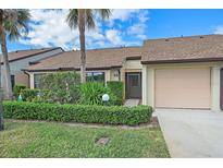 Inviting front yard with lush landscaping and attached garage at 1211 Capri Isles Blvd # 58, Venice, FL 34292