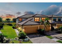 Attractive two-story townhome with tile roof, paver driveway, and attached two-car garage at 20100 Ragazza Cir # 101, Venice, FL 34293