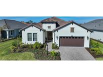 Charming single-story home with a brown two-car garage and landscaped yard at 26069 Norman Dr, Englewood, FL 34223