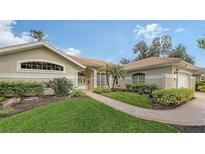 Single-story home with landscaped lawn, walkway, and attached garage at 275 Royal Oak Way, Venice, FL 34292