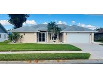 Single-story home with a two-car garage and well-manicured lawn at 338 Woodvale Dr, Venice, FL 34293