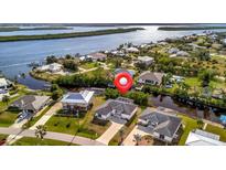 An aerial view shows waterfront homes with well-kept lawns, private docks, and easy access to the river at 3436 Santa Clara Dr, Punta Gorda, FL 33983
