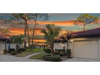 Exterior view of condo with landscaped grounds and a sunset at 3667 Yellow Pine Ct # 149, Sarasota, FL 34238