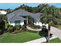 Beautiful home with a tile roof, lush landscaping, and a paver driveway, creating great curb appeal at 589 Pond Willow Ln, Venice, FL 34292