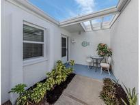 Inviting front courtyard with lush landscaping and seating area at 751 Capri Isles Blvd # 108, Venice, FL 34292