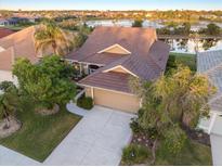 Stunning aerial view of a home showcasing a tile roof and a scenic lake in a vibrant community at 1307 Highland Greens Dr, Venice, FL 34285
